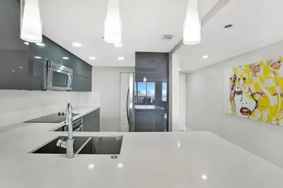 a kitchen with a sink and a painting on the wall at Enchanted! Miami Skyline & Water Views in Miami