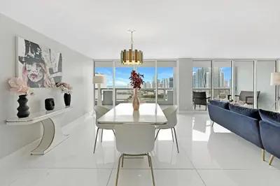 a living room with a table and a blue couch at Enchanted! Miami Skyline & Water Views in Miami