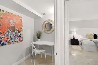a bedroom with a bed and a desk and a painting at Pisces Dream - Direct water views! in Miami