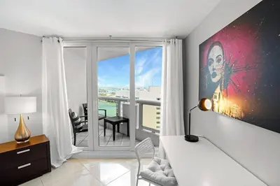 a room with a bed and a view of a balcony at Pisces Dream - Direct water views! in Miami