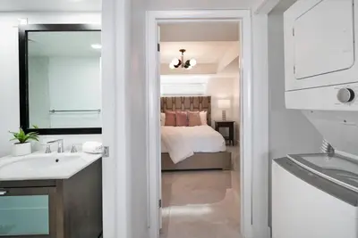 a bathroom with a bed and a sink and a mirror at Classic Beauty! Skyline and water views in Miami
