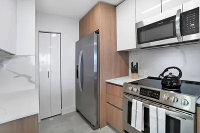 a kitchen with a stove and a stainless steel refrigerator at Classic Beauty! Skyline and water views in Miami