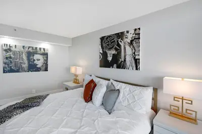 a bedroom with a white bed with two pictures on the wall at The Audrey! Penthouse With Direct Water Views! in Miami