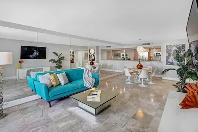 a living room with a blue couch and a table at The Audrey! Penthouse With Direct Water Views! in Miami