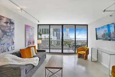a living room with a couch and a table at Shore to Please! Park And Water Views! in Miami