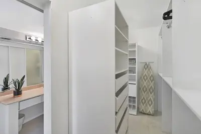 a white walk in closet with a desk and shelves at Shore to Please! Park And Water Views! in Miami
