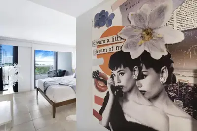 a bedroom with a poster of a woman with a flower on her head at Shore to Please! Park And Water Views! in Miami