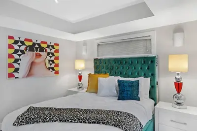 a bedroom with a large bed with a green headboard at The Marilyn! Renovated and Amazing Skyline Views! in Miami
