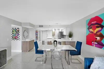 a kitchen with a dining table and blue chairs at The Marilyn! Renovated and Amazing Skyline Views! in Miami