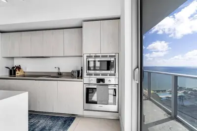 a kitchen with stainless steel appliances and a view of the ocean at HydeHotel 2BED Lux Condo Ocean View Resort in Hollywood