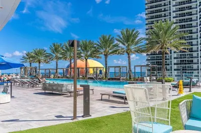 a resort with a pool and palm trees and buildings at HydeHotel 2BED Lux Condo Ocean View Resort in Hollywood