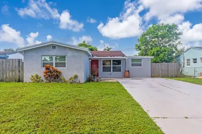 a house with a fence in a yard at Trendy Family Home -Heated Pool in Hollywood