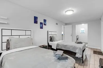 a white room with two beds and a mirror at Trendy Family Home -Heated Pool in Hollywood