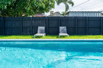 two chairs sitting next to a swimming pool at Trendy Family Home -Heated Pool in Hollywood