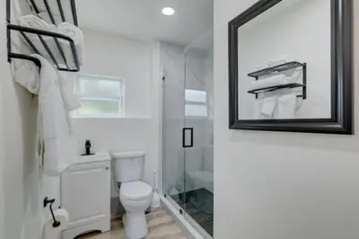 a bathroom with a toilet and a shower and a mirror at Bahama Mama Las Olas and Holiday Park w Hot Tub in Fort Lauderdale