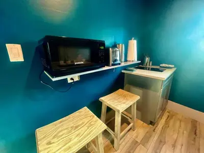 a kitchen with a microwave and a sink and a stool at Moody Stoody-O in Las Olas Beach and Holiday Park in Fort Lauderdale