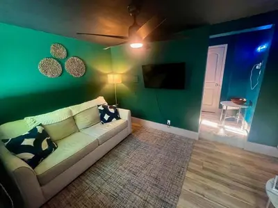 a living room with a couch and a green wall at Moody Stoody-O in Las Olas Beach and Holiday Park in Fort Lauderdale