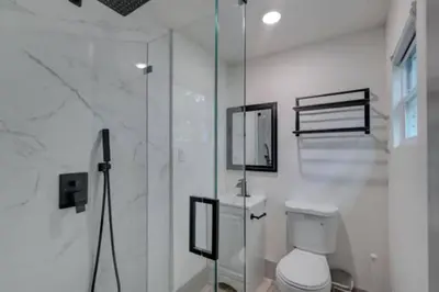 a bathroom with a toilet and a glass shower at Moody Stoody-O in Las Olas Beach and Holiday Park in Fort Lauderdale