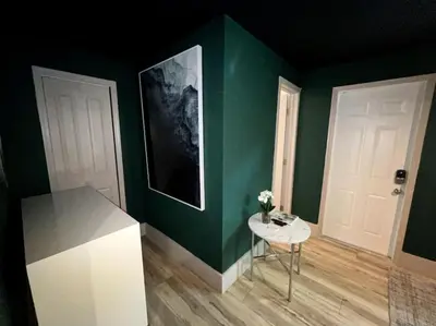 a room with green walls and a table with flowers on it at Moody Stoody-O in Las Olas Beach and Holiday Park in Fort Lauderdale