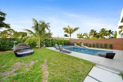 a backyard with a swimming pool and a lawn at The Elements Home with 2 Pools in Fort Lauderdale