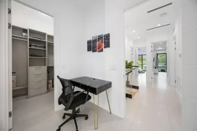 a white hallway with a black desk in a house at The Elements Home with 2 Pools in Fort Lauderdale