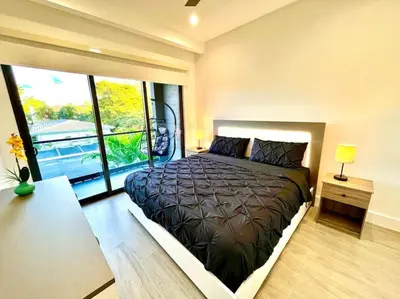 a bedroom with a large bed with a large window at Botanical Oasis Home with 2 Pools in Fort Lauderdale