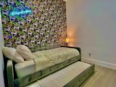 a bed in a room with a wall at Botanical Oasis Home with 2 Pools in Fort Lauderdale