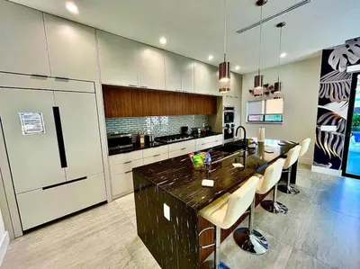 a kitchen with a large island in the middle of a room at Botanical Oasis Home with 2 Pools in Fort Lauderdale