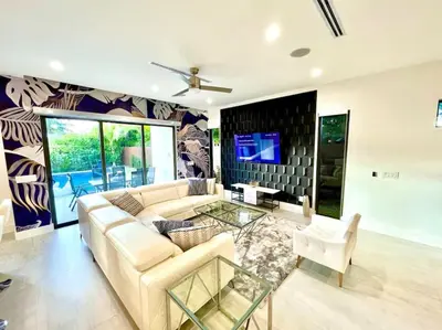 a living room with a couch and a glass table at Botanical Oasis Home with 2 Pools in Fort Lauderdale