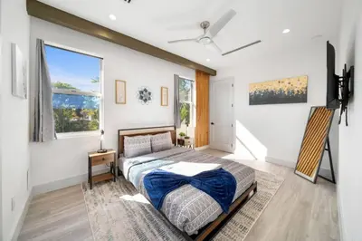 a bedroom with a bed and two windows at Luxury Home w 2 Pools near Beach in Fort Lauderdale