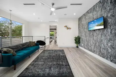 a living room with a couch and a tv on a wall at Luxury Home w 2 Pools near Beach in Fort Lauderdale