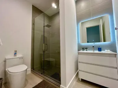 a bathroom with a toilet and a glass shower at The Botanicals Las Olas Near Beach in Fort Lauderdale