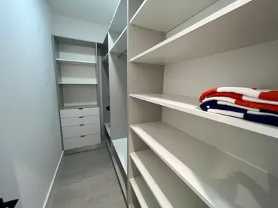a walk in closet with white walls and white shelves at The Botanicals Las Olas Near Beach in Fort Lauderdale