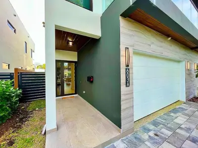 a garage with a white garage door on a house at The Botanicals Las Olas Near Beach in Fort Lauderdale