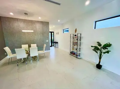a dining room with a table and chairs and a plant at The Botanicals Las Olas Near Beach in Fort Lauderdale