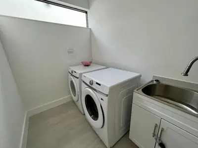 a kitchen with a washing machine and a sink at The Botanicals Las Olas Near Beach in Fort Lauderdale
