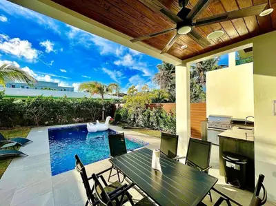 a patio with a table and chairs and a swimming pool at The Botanicals Las Olas Near Beach in Fort Lauderdale