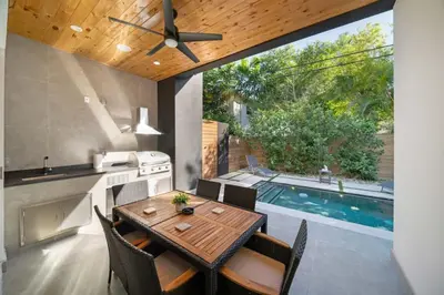 a kitchen and dining room with a table and a swimming pool at Las Olas Zen Home with Pool and Hot Tub Near Beach in Fort Lauderdale