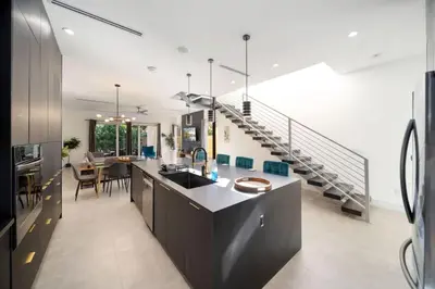 a kitchen and dining room with a staircase in a house at Las Olas Zen Home with Pool and Hot Tub Near Beach in Fort Lauderdale