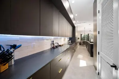 a kitchen with a long counter in a room at Las Olas Zen Home with Pool and Hot Tub Near Beach in Fort Lauderdale