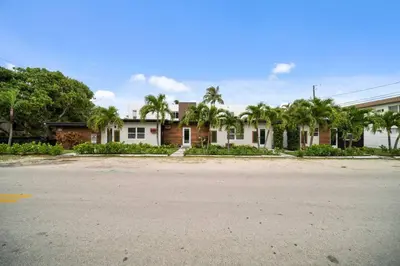 an empty street in front of a house with palm trees at Newly Renovated Tropical Oasis Near Las Olas Beach in Fort Lauderdale
