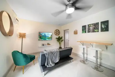 a living room with a table and a green chair at Newly Renovated Tropical Oasis Near Las Olas Beach in Fort Lauderdale