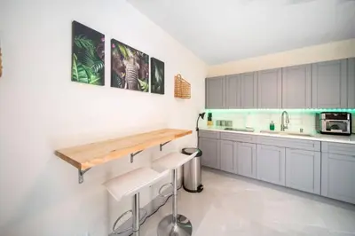 a kitchen with white cabinets and a wooden counter top at Newly Renovated Tropical Oasis Near Las Olas Beach in Fort Lauderdale