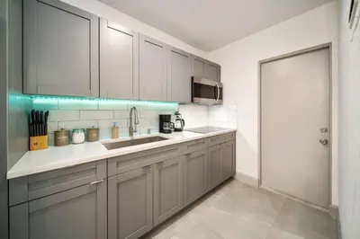 a kitchen with white cabinets and a sink at Las Olas Newly Renovated Coastal 1BR Near Beach in Fort Lauderdale