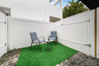 two chairs and a table on a patio with grass at Las Olas Newly Renovated Coastal 1BR Near Beach in Fort Lauderdale
