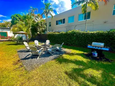 a backyard with a table and chairs and a grill at SuaveMauve Las Olas Beach in Fort Lauderdale