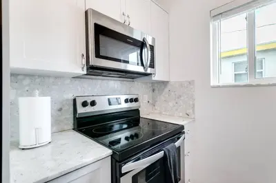 a kitchen with a stove and a microwave at Cozy Little Havana Apt Centrally located Hv2 in Miami