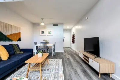 a living room with a blue couch and a tv at Airport Loft 1b full kitchen Virg 10 in Miami