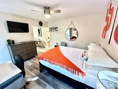 a bedroom with a bed with an orange blanket at The Agustin Guesthouse - Men Only Clothing Optional in Fort Lauderdale