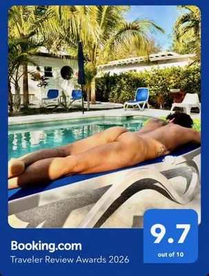 a man laying on a towel next to a swimming pool at The Agustin Guesthouse - Men Only Clothing Optional in Fort Lauderdale
